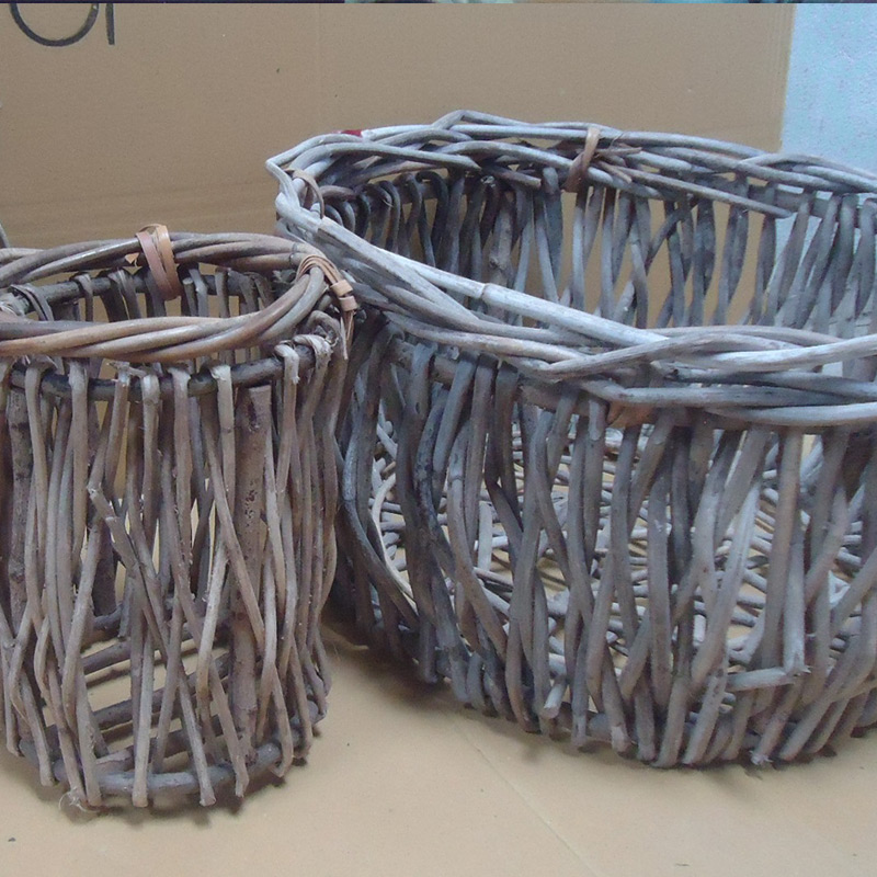 Rustic willow storage basket holding blankets and firewood near fireplace in living room